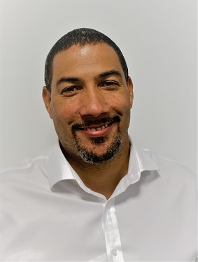Daniel Robinson, olive skin, dark hair and short manicured beard wearing white shirt